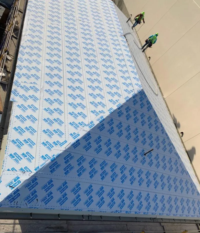 Professional roofers installing underlayment on a metal roof in Alhambra